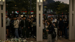Stunned mourners gather outside ruins of Hong Kong housing estate blaze